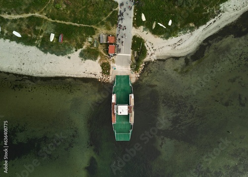 Foto Aerial view of a large vessel docked in a port, with a body of water in the back