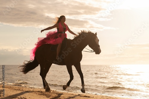 a woman riding a horse on the beach near water's edge © Zelma Brezinska/Wirestock Creators