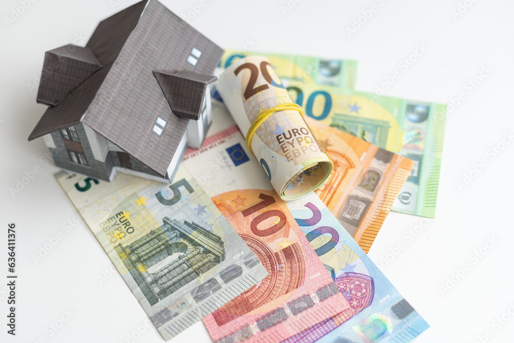 Concept of expenses for new home; small house, dollar paper money. Concept of expenses for new home; small house, dollar paper money.