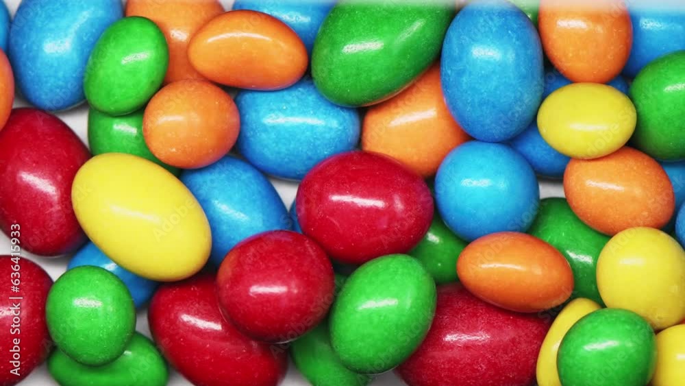 Multi-colored candy drops down and filled the screen. Closeup video of colorful chocolate candies. Multi-colored candy drops down and filled the screen. Closeup video of colorful chocolate candies.