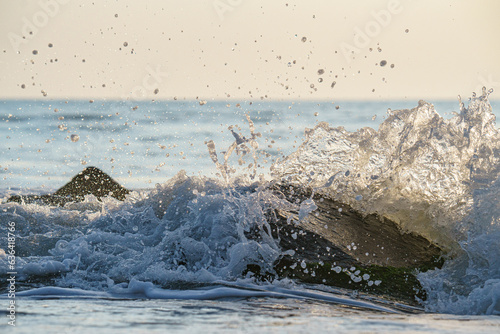 Beautiful shot of a moment of splash made while the water hitting a big rock in the sea