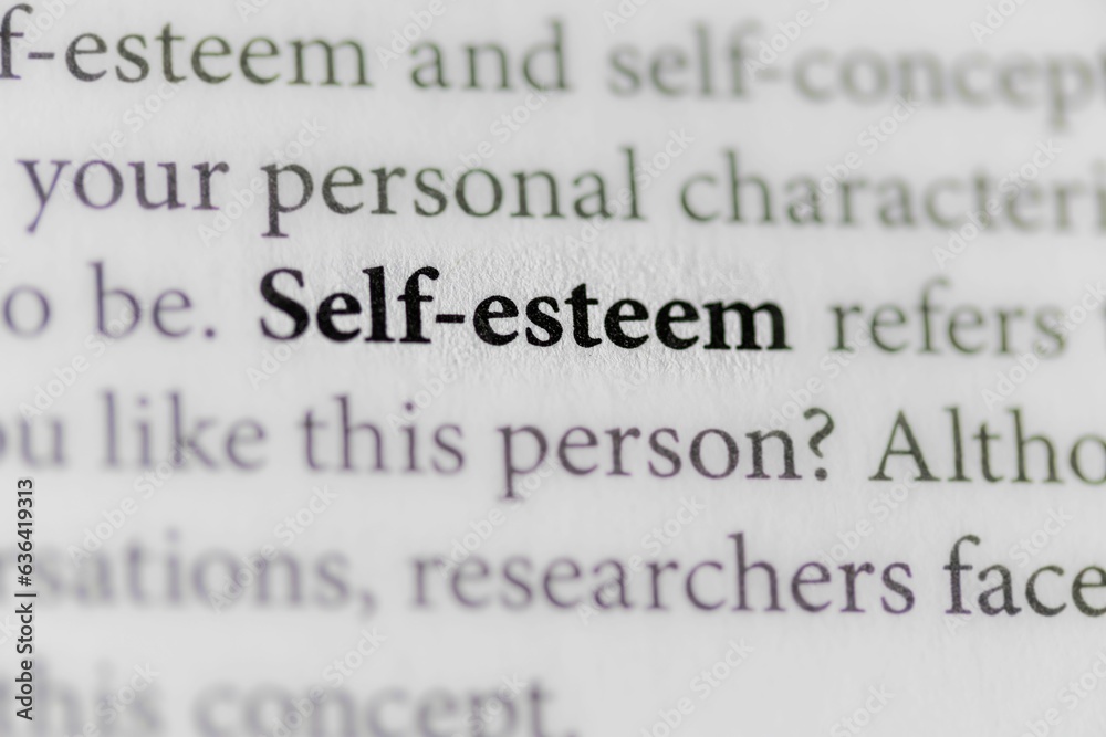 Open book with the word 'Self-Esteem' written on the page in bold, black lettering Open book with the word 'Self-Esteem' written on the page in bold, black lettering