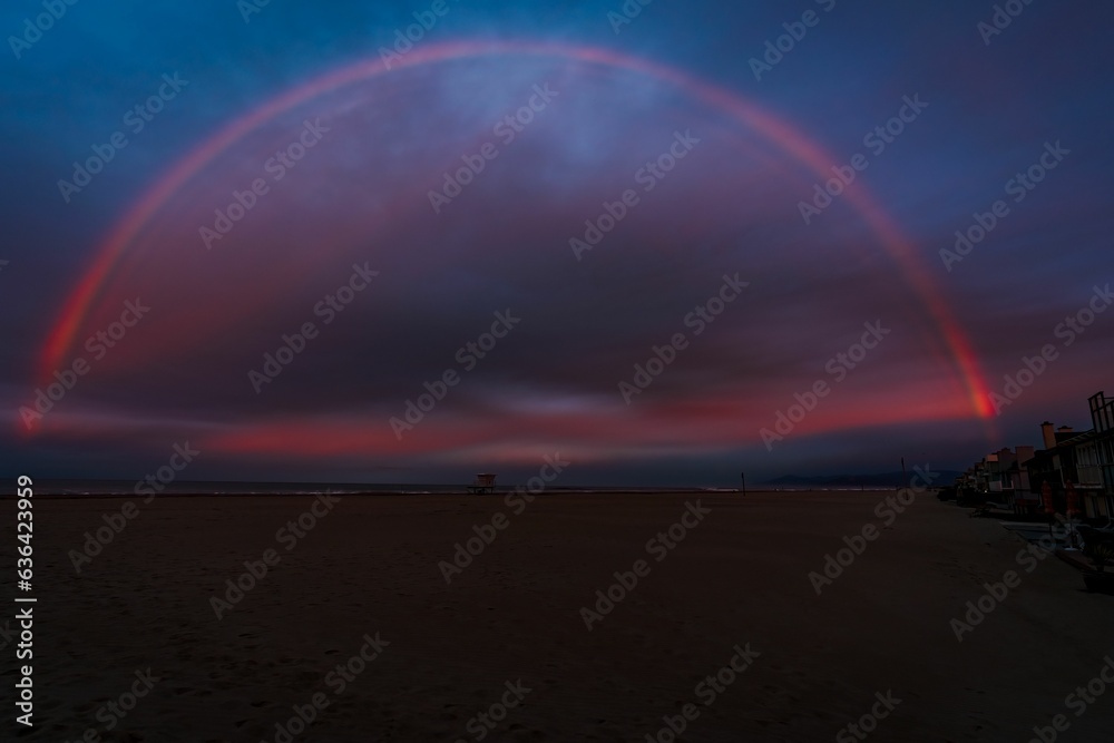 Beautiful rainbow over the Hollywood Beach with the purple sunset sky in the background Beautiful rainbow over the Hollywood Beach with the purple sunset sky in the background