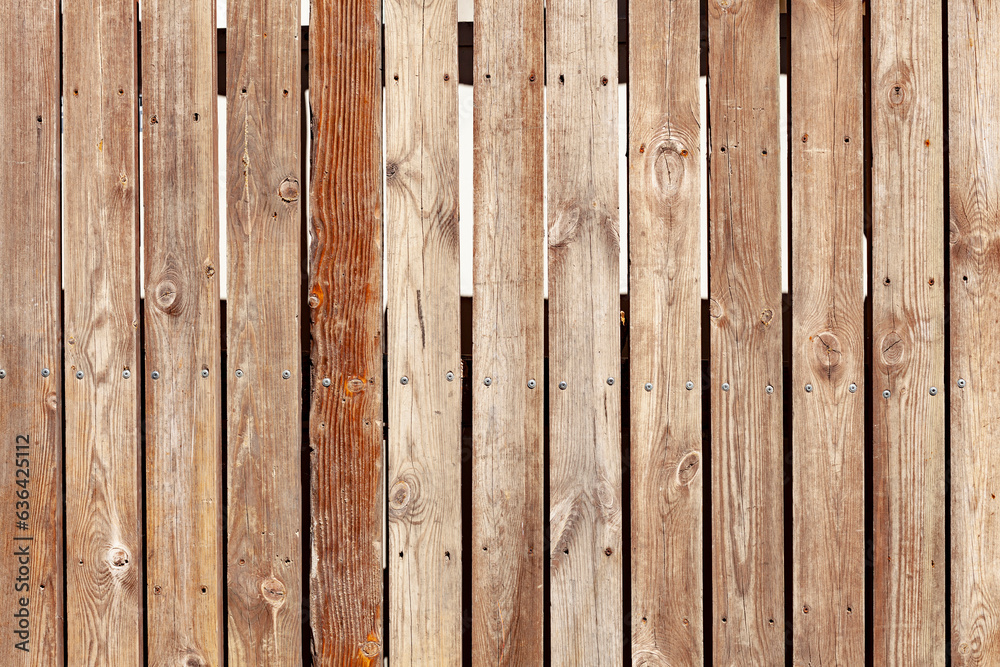 Vertical fence made of timber boards. Used wooden panels. Old hardwood background.