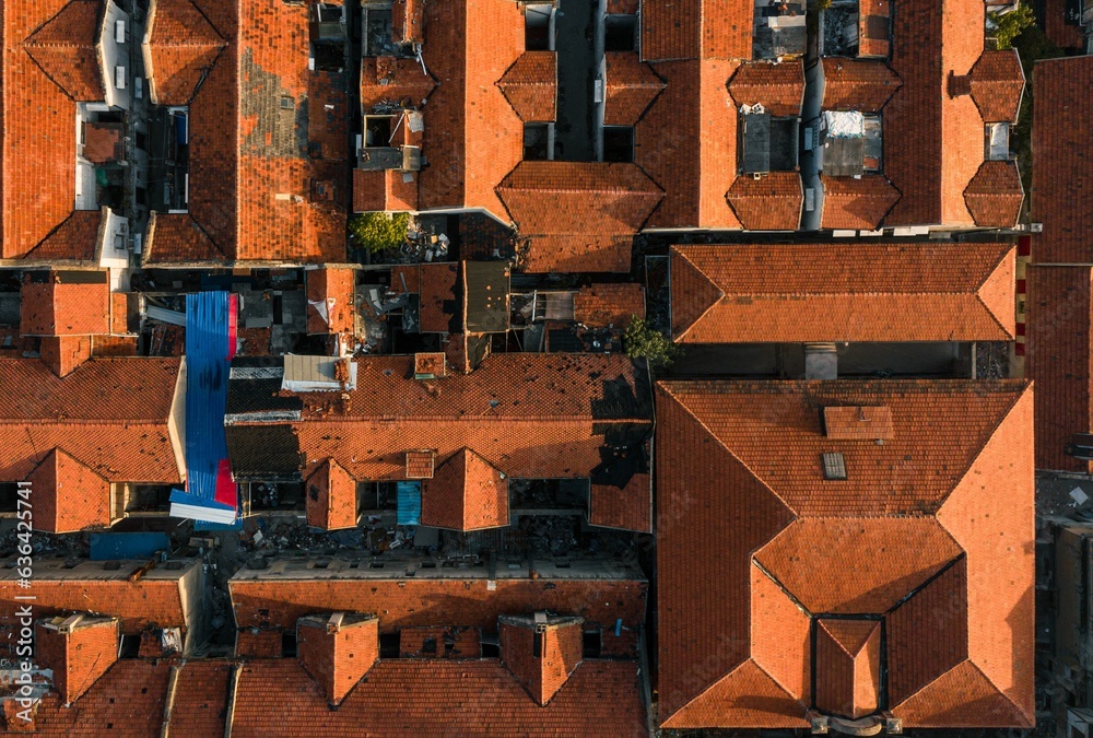 Top-down aerial view of Wuhan's cityscape with red brick building roofs during the daytime