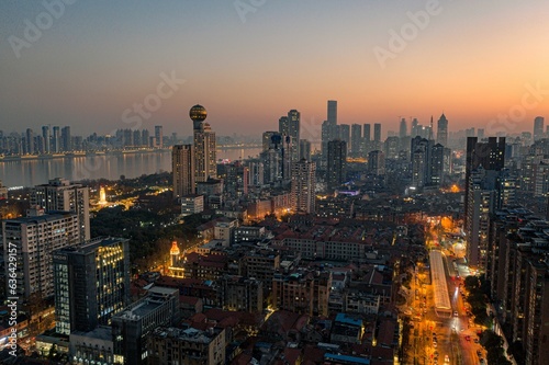 Aerial view of vibrant night-time cityscape featuring illuminated skyscrapers in Wuhan