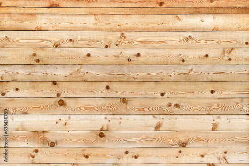 Texture of the wall made of knotty sanded wooden boards with multiple cracks as a retro natural background