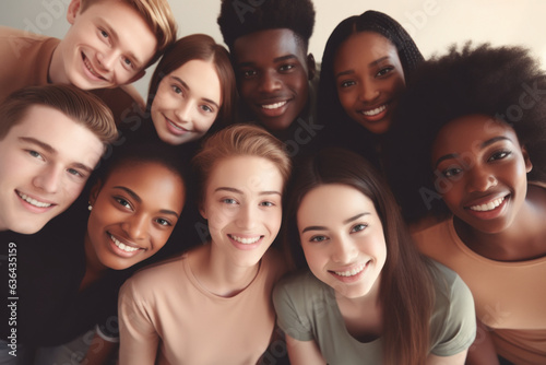 A diverse, multiracial group of students from different ethnic backgrounds capturing a selfie from above in a classroom.