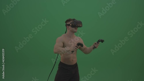 Young Sportsman Drawing Something in virtual Reality Game Using VR Kit On Green Screen Wall Background photo