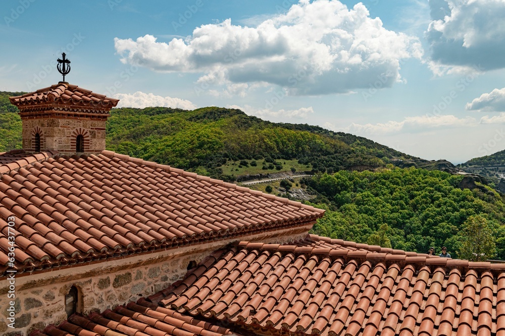 brick house with a red-tiled roof stands nestled in the picturesque landscape of Kalabaka Greece brick house with a red-tiled roof stands nestled in the picturesque landscape of Kalabaka Greece