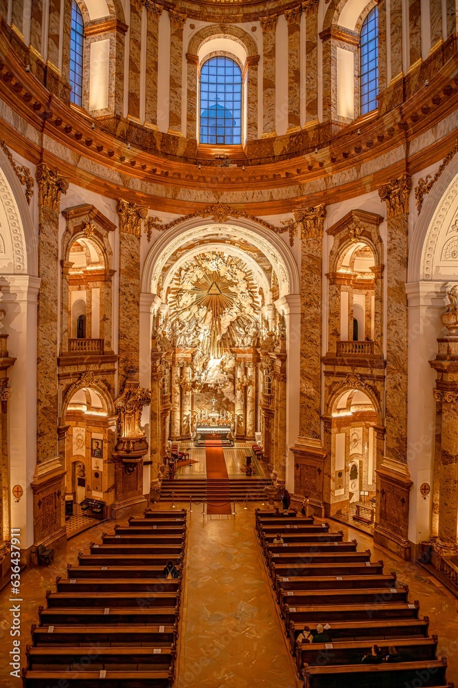 Interior shot of a grand church showcasing ornate pews and stained glass windows: Vienna, Austria