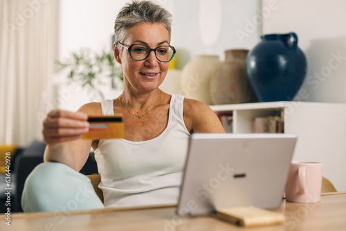 Happy mature woman shopping online.