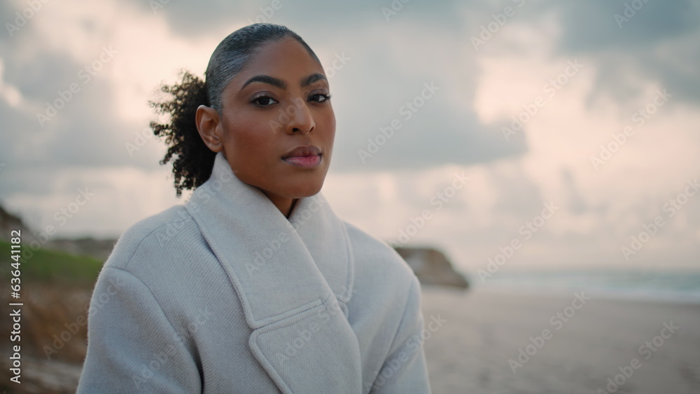 Portrait serious woman look camera at ocean beach. Frustrated pensive model rest Portrait serious woman look camera at ocean beach. Frustrated pensive model rest