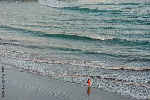 Aerial view of a person walking alone on the beach in Playa del Ingles, Maspalomas, Gran Canaria, Spain