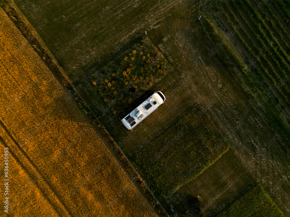Obraz premium Camper Bus auf einem Feld, Top-down, Sonnenuntergang