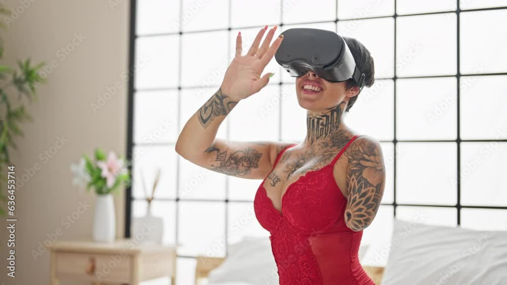 Hispanic woman with amputee arm wearing lingerie sitting on bed using virtual reality glasses at bedroom Hispanic woman with amputee arm wearing lingerie sitting on bed using virtual reality glasses at bedroom