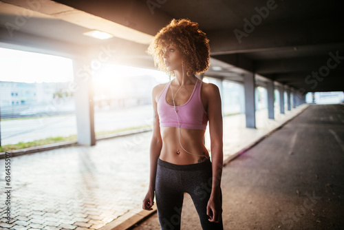Young woman getting ready to go jogging and exercising in a parking lot