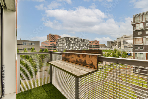 a balcony with grass and buildings in the background, taken from an apartment building's roof top deck area © Casa imágenes