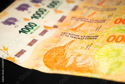 Banknotes of 1000 Argentine pesos, Argentine money, Argentine currency, Argentine pesos. Pile of several thousand Argentine peso bills, one thousand peso bills in cash on black background