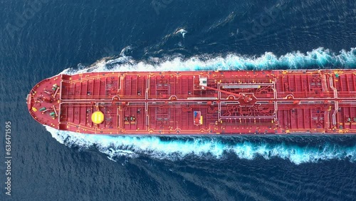Top-down view of a crude oil tanker speeding through calm waters with trails of foam around her. Powerful diesel engine of the oil tanker roars at full speed and leaves wake water on the Ocean
