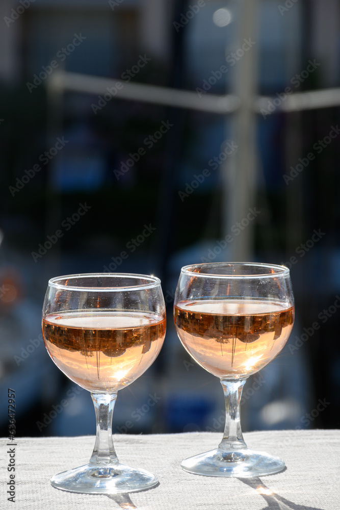 Pouring in glasses of cold rose Cote de Provence wine in yacht harbour of Port Grimaud, summer vacation on French Riviera Provence, France