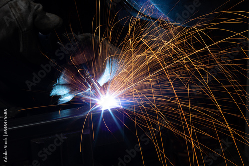 welder, mig or tig welding, craftsman, erecting technical steel Industrial, pretty sparks from weld pistol, steel welder in factory technical photo