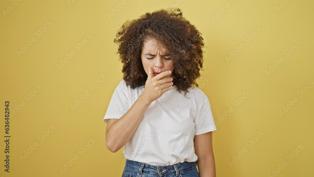 Young beautiful hispanic woman coughing over isolated yellow background Young beautiful hispanic woman coughing over isolated yellow background