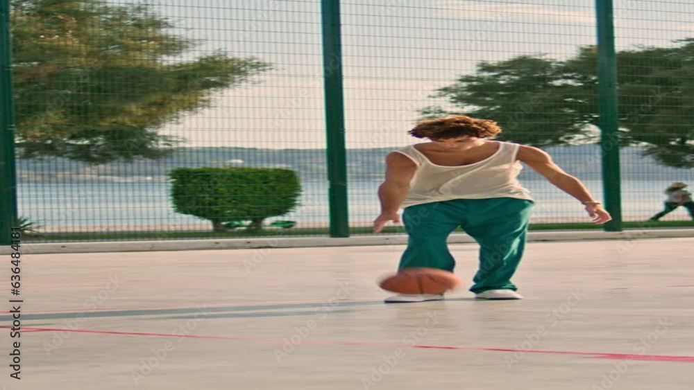 Sportive man practicing street basketball. Focused afro guy training vertically Sportive man practicing street basketball. Focused afro guy training vertically