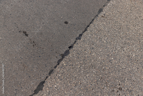 The repaired part of an asphalt road with patches