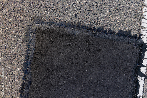 Canvas Print The repaired part of an asphalt road with patches