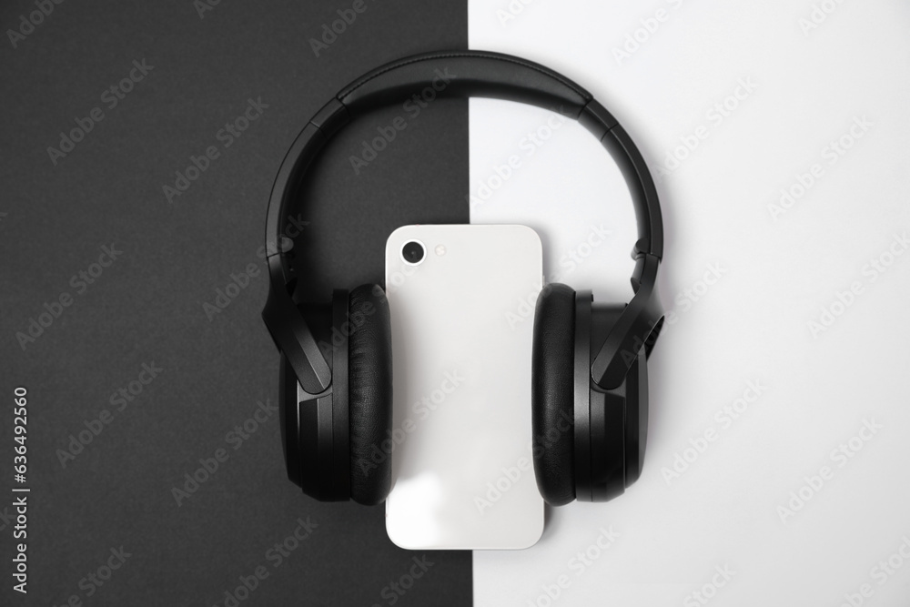 Modern wireless headphones and smartphone on color background, top view Modern wireless headphones and smartphone on color background, top view