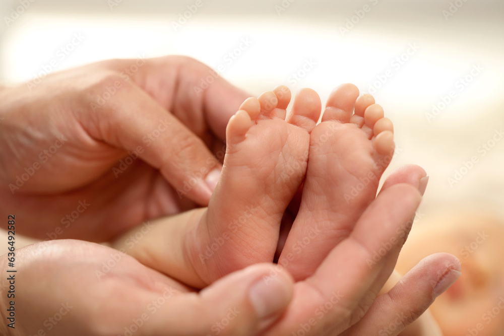 Father holding his newborn baby, closeup view on feet. Lovely family Father holding his newborn baby, closeup view on feet. Lovely family