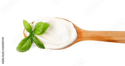 Wooden spoon with tasty mayonnaise and basil isolated on white, top view