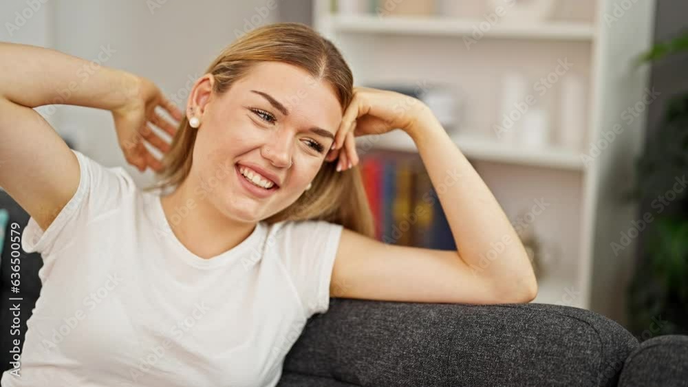 Young blonde woman smiling confident sitting on sofa at home Young blonde woman smiling confident sitting on sofa at home