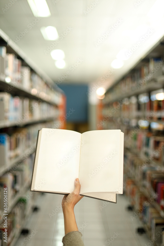 Close up blank pages of book for text or ads with library bookshelves on the background Close up blank pages of book for text or ads with library bookshelves on the background