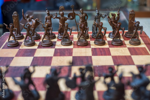 chess pieces made based on greek mythology are on a chessboard