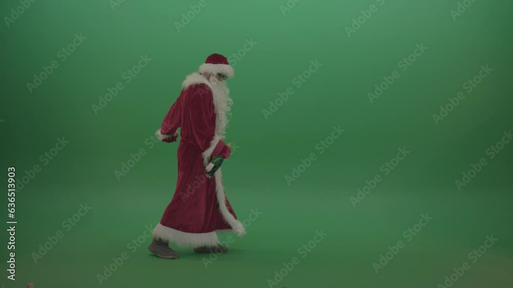 Drunk santa in black glasses with a bottle of wine staggers across the green screen background Drunk santa in black glasses with a bottle of wine staggers across the green screen background
