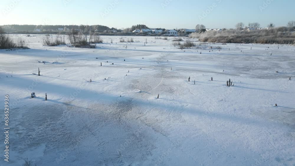 Slow flight over a frozen-over lake in winter Slow flight over a frozen-over lake in winter