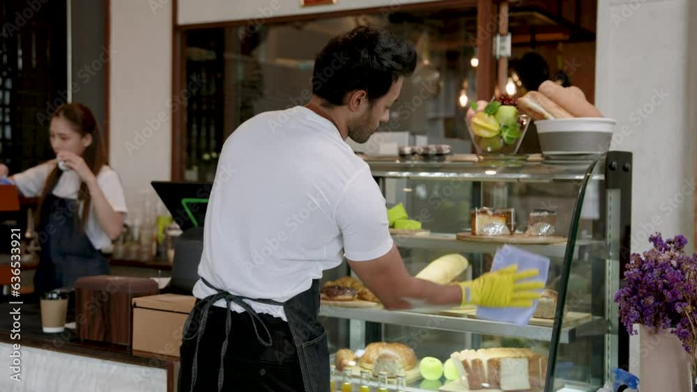 Spanish man owns small family coffee shop, helping wife clean the glass cabinet that holds the cakes. and preparing to open a cafe in the morning of every day to be ready to receive customers Spanish man owns small family coffee shop, helping wife clean the glass cabinet that holds the cakes. and preparing to open a cafe in the morning of every day to be ready to receive customers