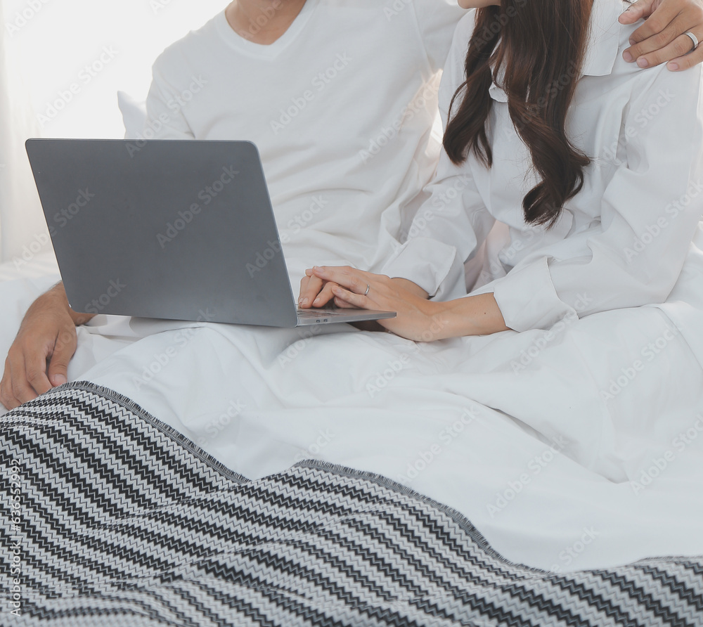 Portrait of young happy couple using laptop at night, using modern technology having fun with glowing screen in dark office or at home, startup business meeting video call distance of young business Portrait of young happy couple using laptop at night, using modern technology having fun with glowing screen in dark office or at home, startup business meeting video call distance of young business