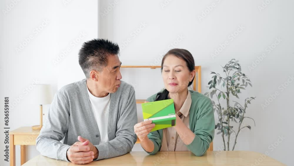 預金通帳を持って考えるシニア夫婦 預金通帳を持って考えるシニア夫婦