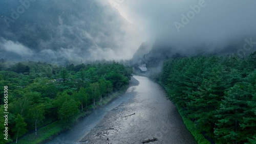 Atmospheric Halloween landscape, foggy morning river in the mountain valley, Kamikochi valley, hiking in Japanese Alps photo