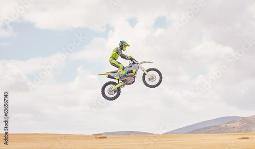 Desert  motorbike cycling and jump for sports  agile driving and off road adventure with mockup space in cloudy sky. Motorcycle  challenge and moving in air for action  fearless talent and sand dunes
