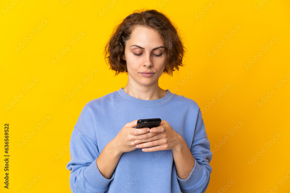 Young English woman isolated on pink background using mobile phone Young English woman isolated on pink background using mobile phone