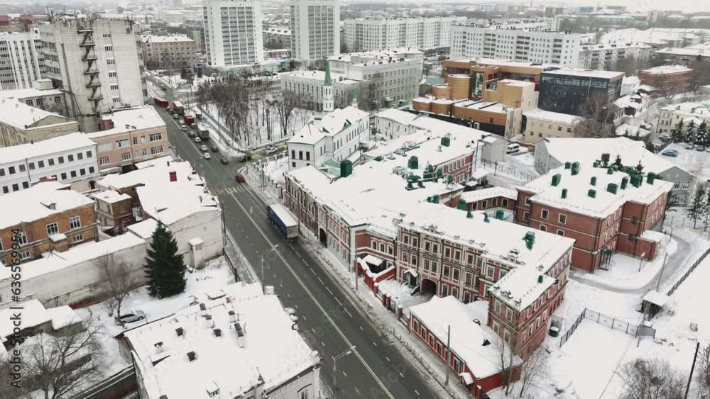 Traffic street road covered with cars passing constructed building with rooftops covered with thick layer of snow. Landscape of winter city Traffic street road covered with cars passing constructed building with rooftops covered with thick layer of snow. Landscape of winter city