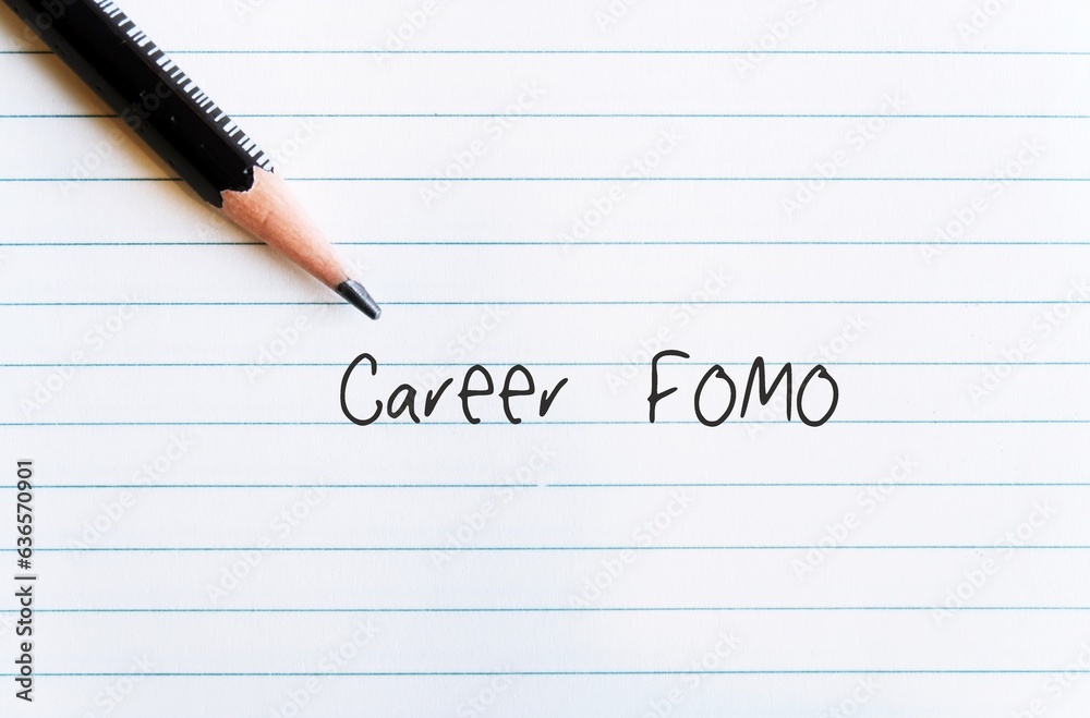 Pencil on office paper with handwritten text CAREER FOMO, means fear of missing out on a job opportunity, the worry that everyone else is achieving and enjoying more success than you Pencil on office paper with handwritten text CAREER FOMO, means fear of missing out on a job opportunity, the worry that everyone else is achieving and enjoying more success than you