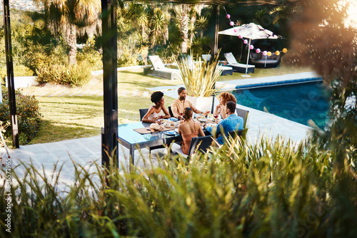 Group, friends or eating in outdoor restaurant to relax on holiday celebration or vacation in summer together. Party, hotel or happy people speaking to bond at table for lunch food or brunch meal