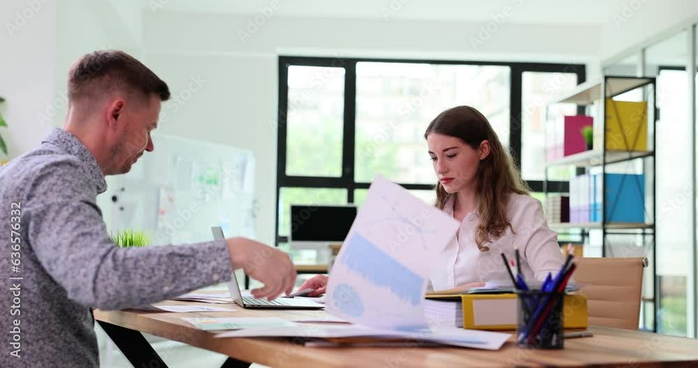 Busy colleagues go through work papers finding document with chart. Concept of workflow of company employees at coworking place slow motion Busy colleagues go through work papers finding document with chart. Concept of workflow of company employees at coworking place slow motion