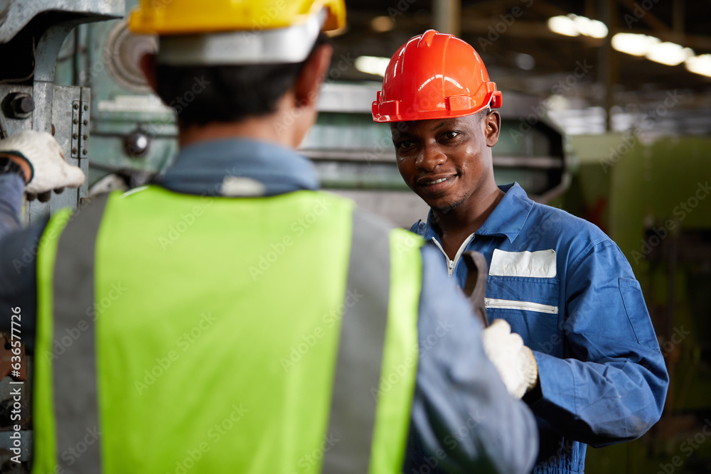 african technician giving or sending wrench to worker for fixing a machine african technician giving or sending wrench to worker for fixing a machine