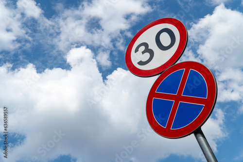 limited speed zone and no stopping sign on a blue cloudy sky